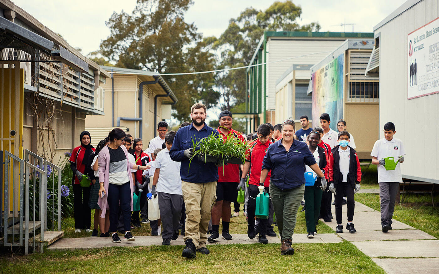 School children and staff walking with plants
