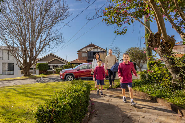 A family of walking away from their car in a suburban neighbourhood